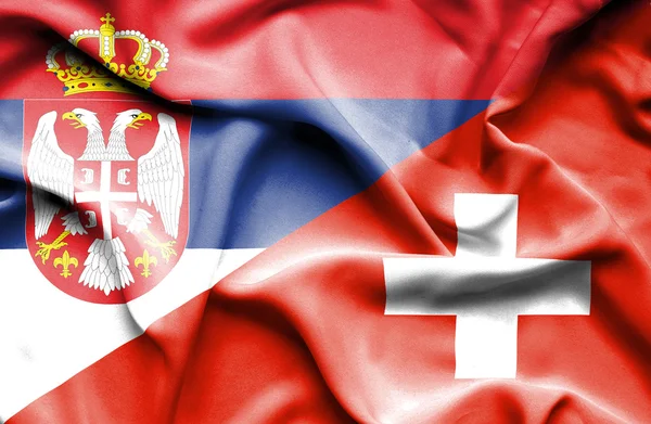 Flagge der Schweiz und Serbiens schwenken — Stockfoto