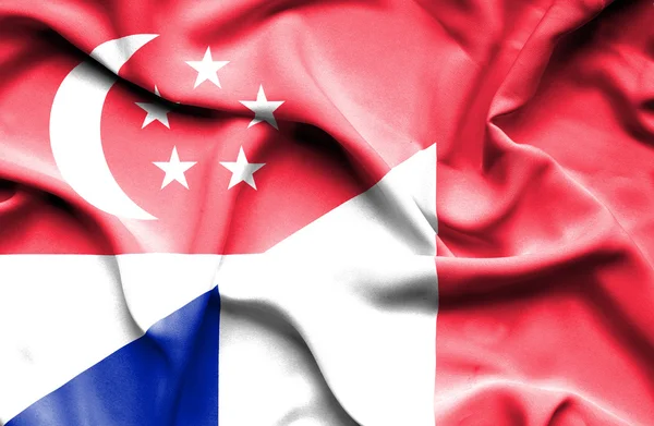 Macha flagą Francji i Singapuru — Zdjęcie stockowe