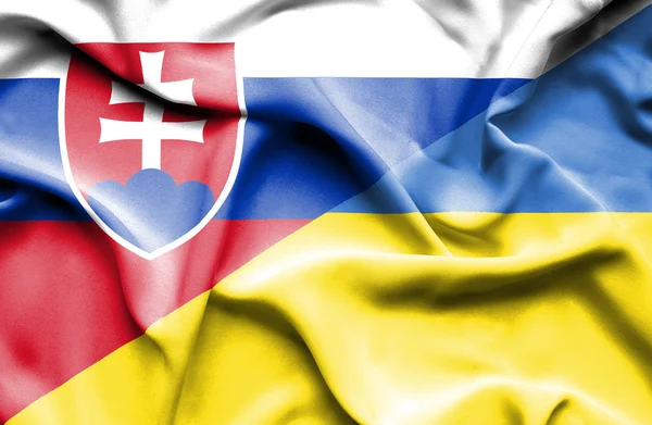Fahne der Ukraine und der Slowakei schwenkend — Stockfoto