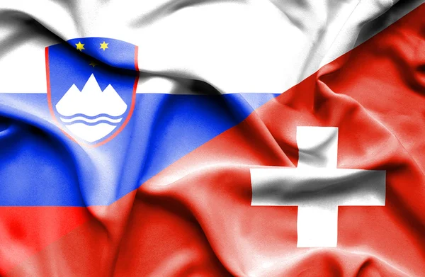 Flagge der Schweiz und Sloweniens schwenkend — Stockfoto