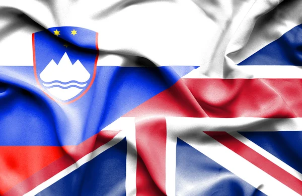 Fahne des vereinigten Königreichs und Sloweniens schwenkend — Stockfoto