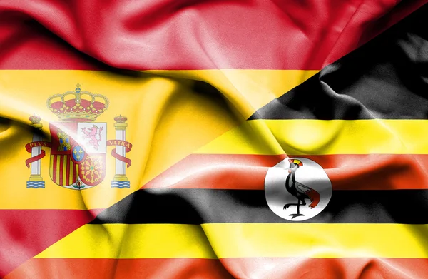 Waving flag of Uganda and Spain — Stock Photo, Image