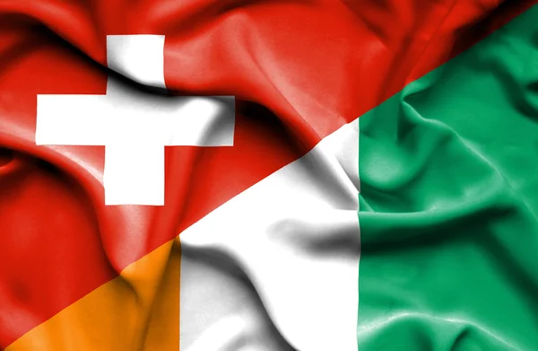 コートジボワール ・ スイス連邦共和国の旗を振っています。 — ストック写真