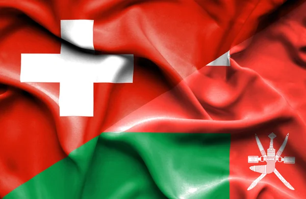 Omán és Svájc hullámzó zászlaja — Stock Fotó