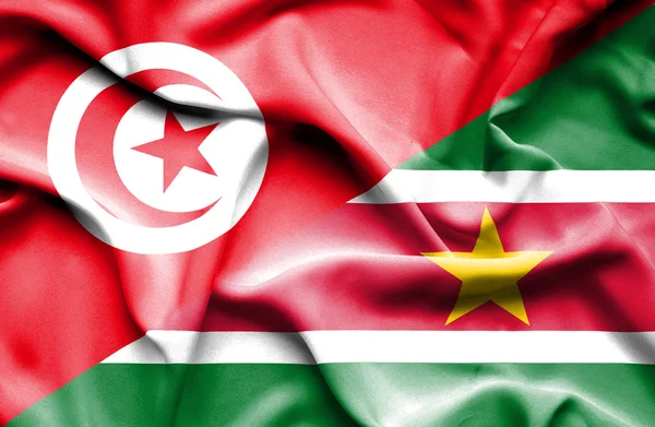 Surinamen ja Tunisian lippu heiluu — kuvapankkivalokuva