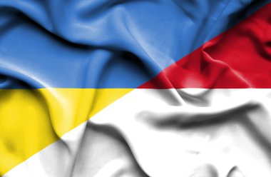 Waving flag of Monaco and Ukraine