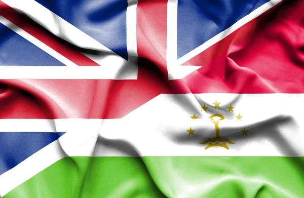 Waving flag of Tajikistan and Great Britain — Stock Photo, Image