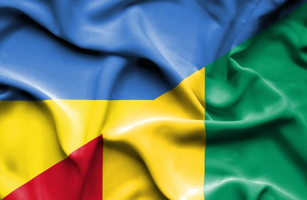 Waving flag of Guinea and Ukraine — Stockfoto