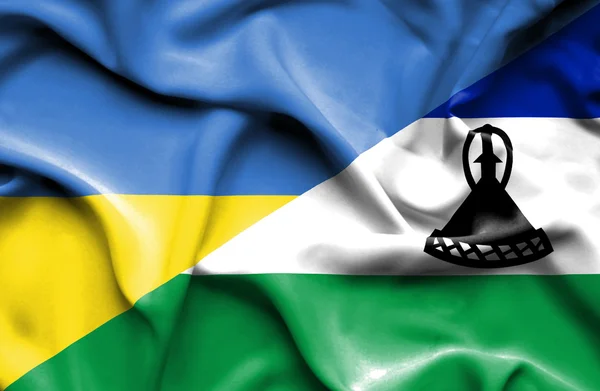 Waving flag of Lesotho and Ukraine — Stok fotoğraf