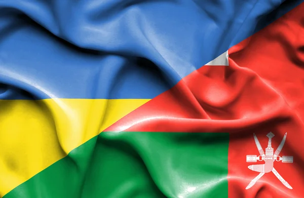 Waving flag of Oman and Ukraine — Stok fotoğraf