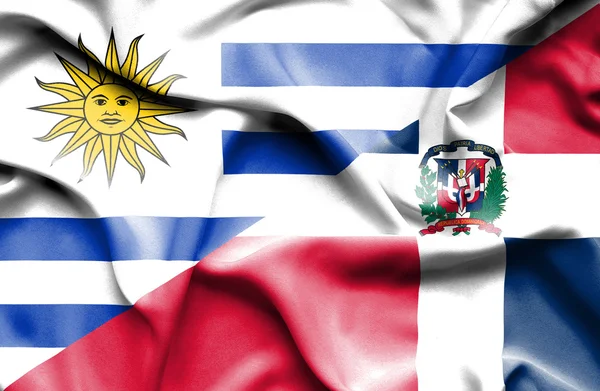 Waving flag of Dominican Republic and Uruguay — Stockfoto