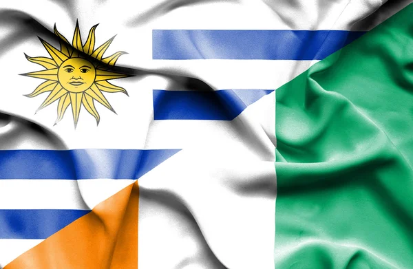 Waving flag of Ivory Coast and Uruguay — Stock Photo, Image