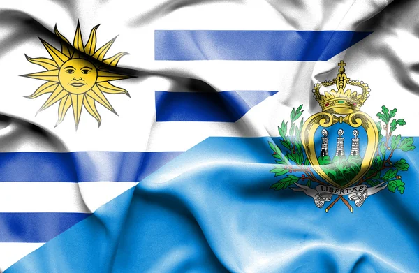 Vlající vlajka san Marina a uruguay — Stock fotografie
