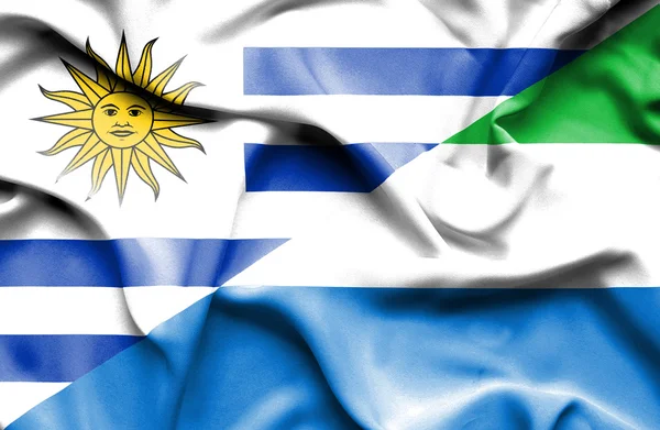 Waving flag of Sierra Leone and Uruguay — Stok fotoğraf