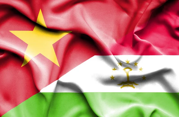 Waving flag of Tajikistan and Vietnam — Stok fotoğraf