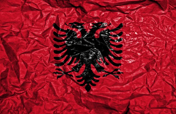 Vintage vlajka Albánie na starém červeném pozadí — Stock fotografie