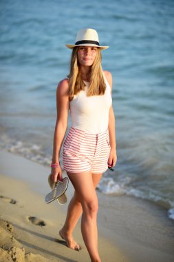 Yaz tatilde kumsalda yürüyen mutlu güzel plaj kadın