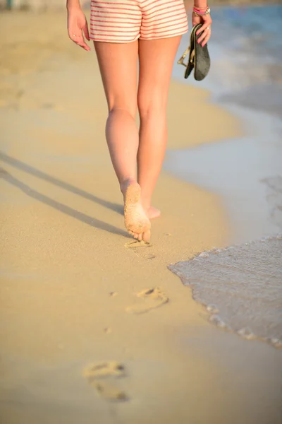 Viaje a la playa - mujer caminando en la playa de arena dejando huellas en —  Fotos de Stock