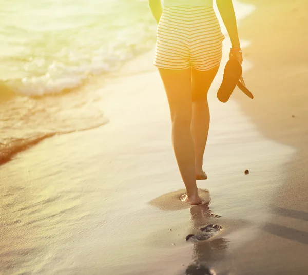 Viaje a la playa - mujer caminando en la playa de arena dejando huellas en —  Fotos de Stock