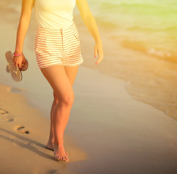 Viaje a la playa - mujer caminando en la playa de arena dejando huellas en — Foto de Stock