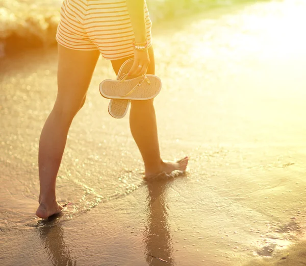 Viaggio in spiaggia - donna che cammina sulla spiaggia di sabbia lasciando impronte in — Foto Stock