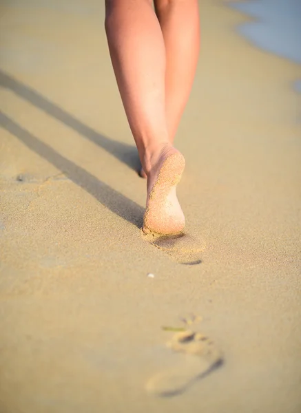 Viagens de praia - mulher andando na praia deixando pegadas em — Fotografia de Stock