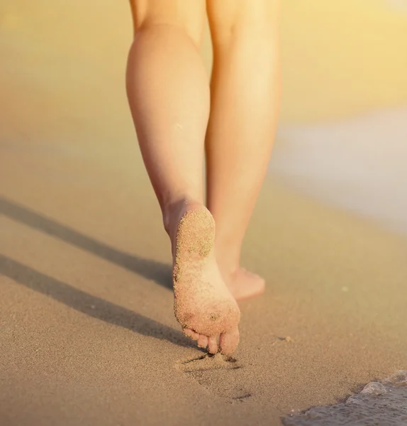 Viaje a la playa - mujer caminando en la playa de arena dejando huellas en — Foto de Stock