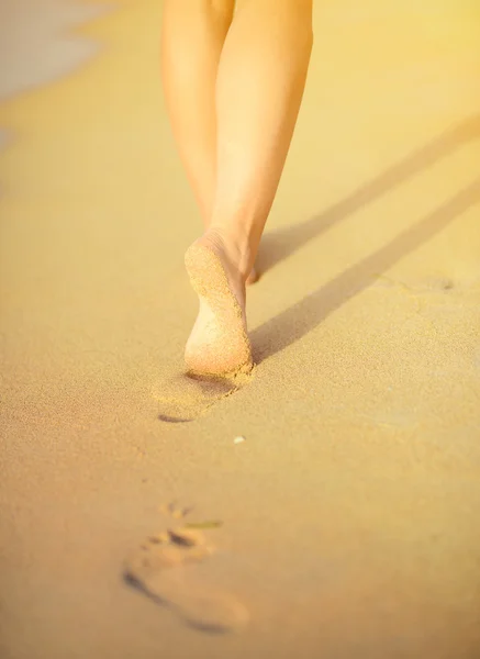 Viaje a la playa - mujer caminando en la playa de arena dejando huellas en — Foto de Stock