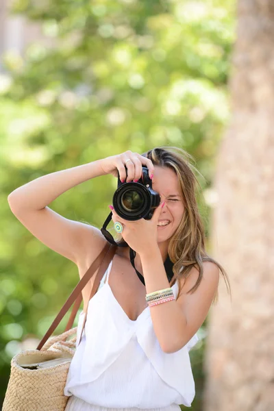 Mujer feliz fotógrafa sosteniendo una cámara dslr — Foto de Stock