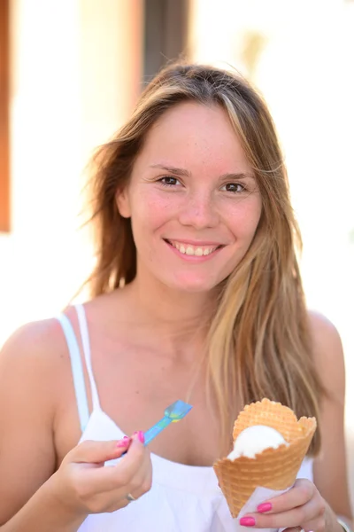 Retrato de una joven mujer feliz comiendo helado al aire libre — Foto de Stock