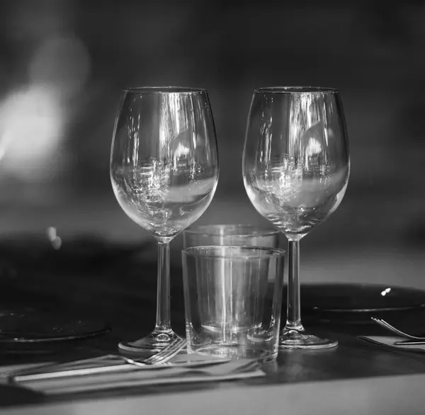 Empty glasses in restaurant, black and white photo — Stock Photo, Image