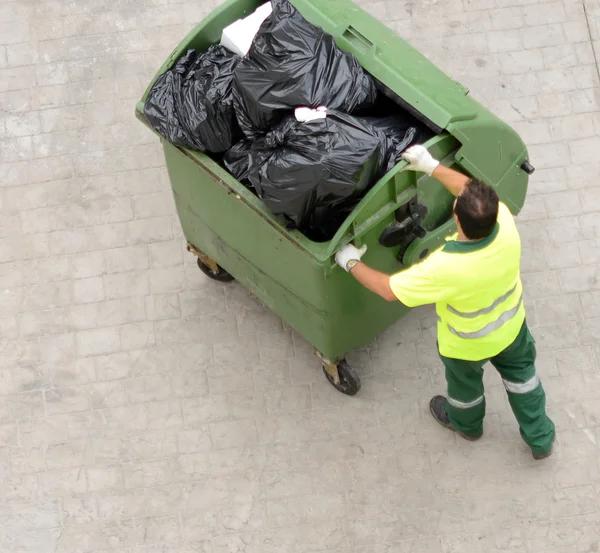 Man from city service pulling garbage bin — Stock Photo, Image