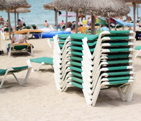 Camas de sol apiladas en la playa —  Fotos de Stock