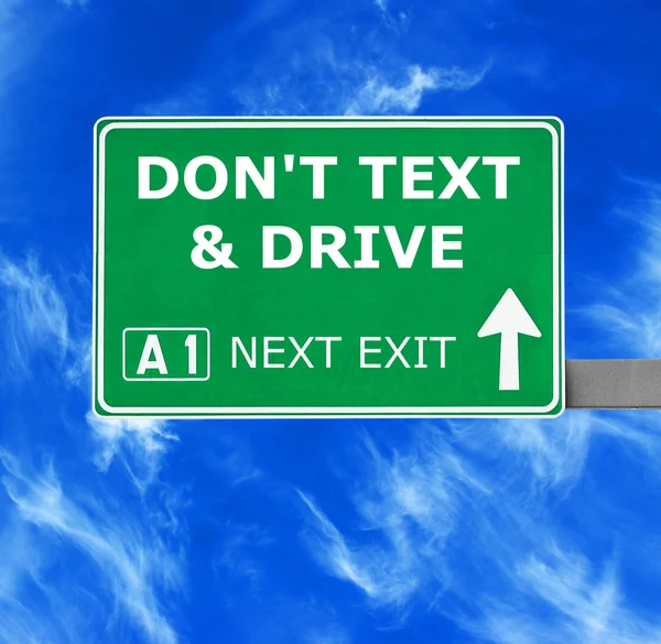 Don 't TEXT & DRIVE road sign against clear blue sky — стоковое фото
