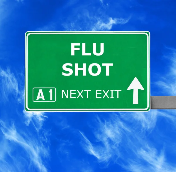 FLU SHOT señal de tráfico contra el cielo azul claro —  Fotos de Stock