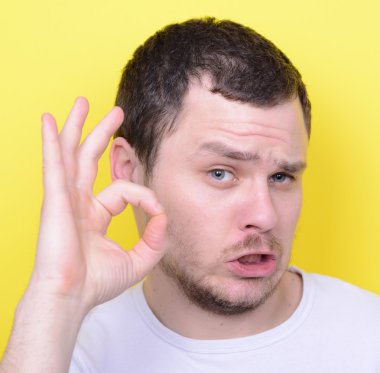 Portrait of funny man showing OK gesture with hands against yell
