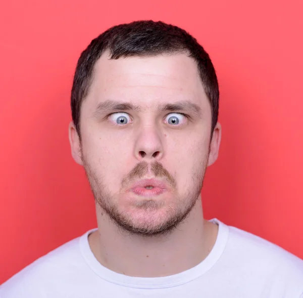 Portrait of man with funny face against red background — Stock Photo, Image