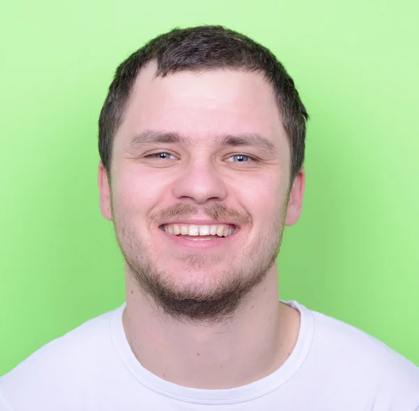 Portret van knappe man die lacht tegen groene achtergrond — Stockfoto