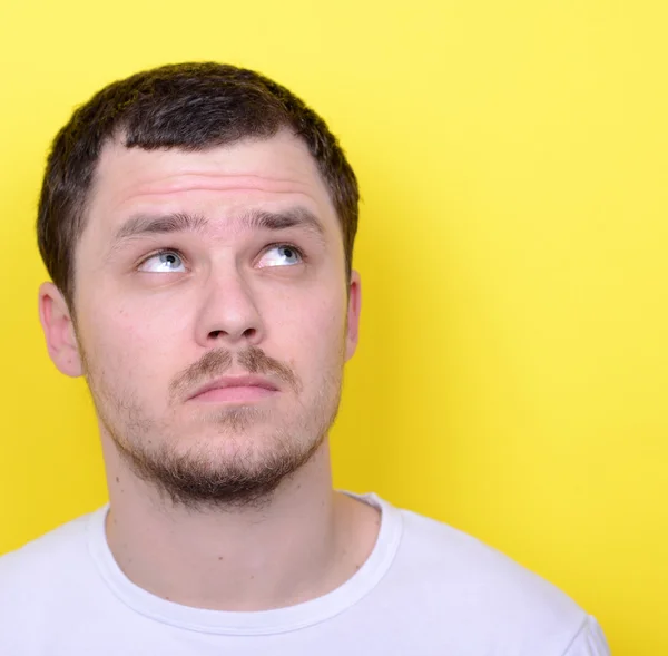 Retrato de jovem feliz olhando para cima contra fundo amarelo — Fotografia de Stock