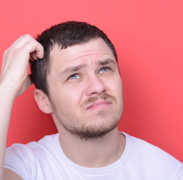 Portrait of man thinking against red background — Stock Photo, Image