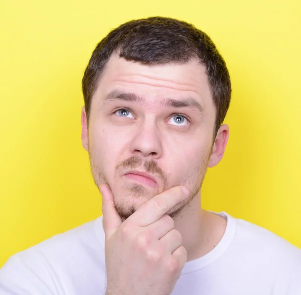 Portrait of man thinking and looking up against yellow backgroun — Stock Photo, Image