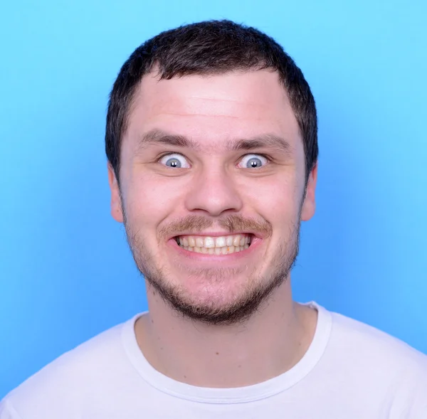 Retrato de homem com rosto engraçado contra fundo azul — Fotografia de Stock