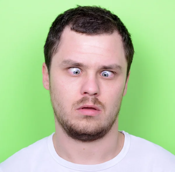 Портрет человека со смешным лицом на зеленом фоне — стоковое фото