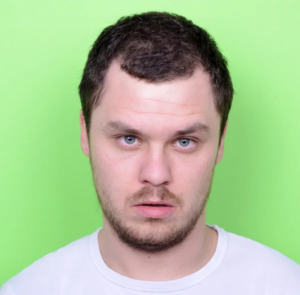 Retrato de homem com rosto engraçado contra fundo verde — Fotografia de Stock