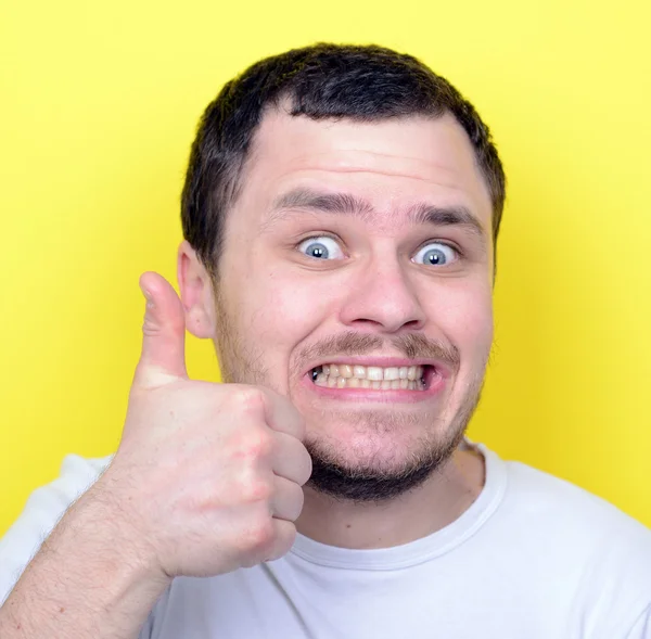 Портрет со смешным выражением лица, держащим большие пальцы против крика — стоковое фото