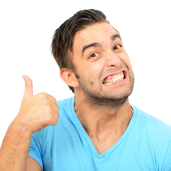 Portrait of with funny expression holding thumbs up against whit — Stock Photo, Image