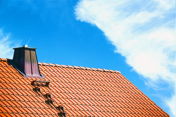 Крыша дома на фоне ярко-синего неба — стоковое фото