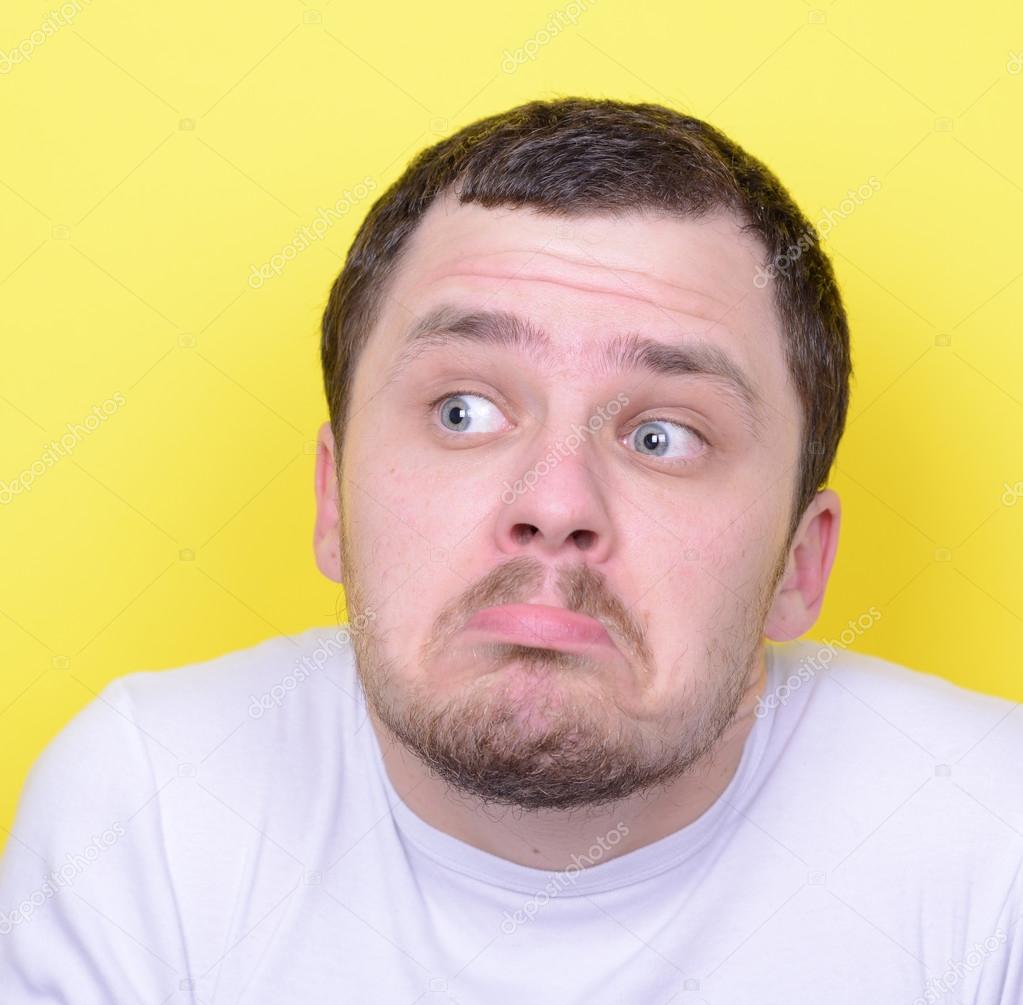 Portrait of funny cluelles man against yellow background