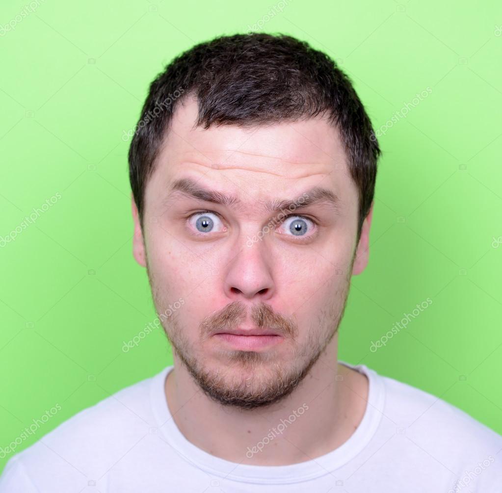 Portrait of man with funny face against green background