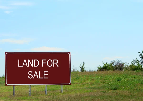 Land for sale sign in empty field — Stock Photo, Image